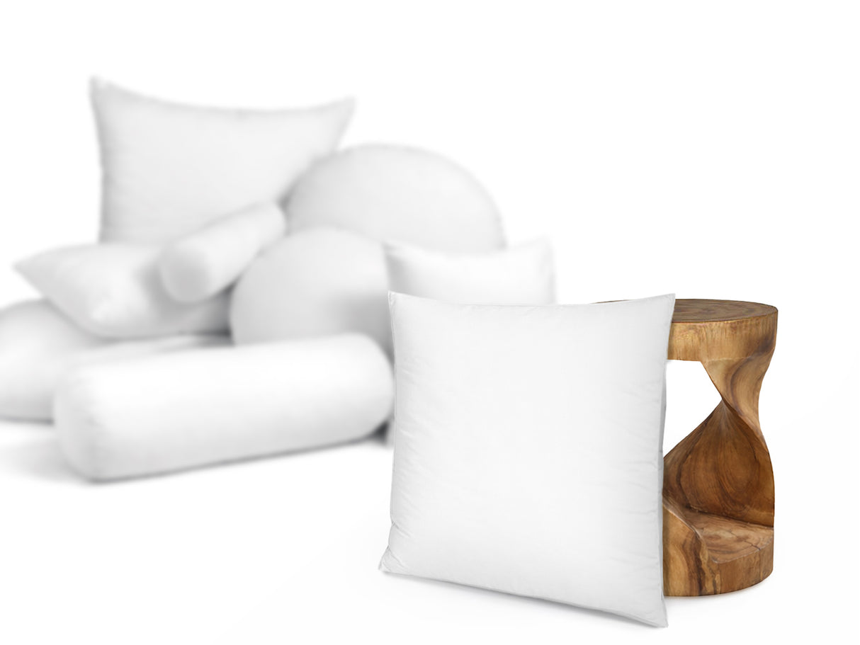 beties PublikFree Polyesterflocken Kopfkissen 80x80 cm – Größenvergleich neben einem Holzhocker, veganes Schlafkissen ohne Federn, klassische Füllung