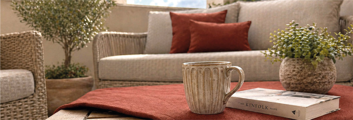 WunschTON Kissenbezüge in Rostrot auf einem Sofa, kombiniert mit passendem Tischläufer als abgestimmte Wohntextilien für Wohnzimmer und Wohnbereich.