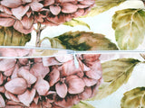 Weisser Bezug für Nackenrollen im Landhausstil, bedruckt mit rosa/pinken Hortensien-Blueten. Nahaufnahme des geoeffneten Reissverschluss.