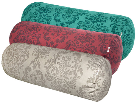 Drei Kissenrollen hintereinander, bezogen mit Kissenbezuegen in den Farben Beige, Rot und Petrol. Bedruckt sind die Bezuege mit barocken Ornamenten in der jeweiligen Farbe, nur etwas dunkler.