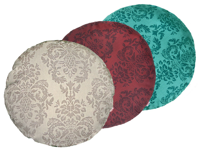 Drei runde Kissen hintereinander, bezogen mit Kissenbezuegen in den Farben Beige, Rot und Petrol. Bedruckt sind die Bezuege mit barocken Ornamenten in der jeweiligen Farbe, nur etwas dunkler.