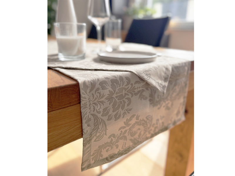 Beiger Tischlaeufer, bedruckt mit barocken Ornamenten in einem dunkleren beige.