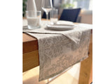 Beiger Tischlaeufer, bedruckt mit barocken Ornamenten in einem dunkleren beige.