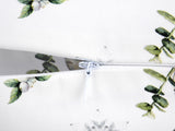 Weisse Nackenrollenhuelle ca. 15x40 cm – Winterdeko mit orangen, gefrosteten Rosen, Tannenzapfen und Zweigen. Detailansicht des Reissverschluss. – 100% Baumwolle – Aus der beties Magie des Winters "Frost-Rose" Kollektion.